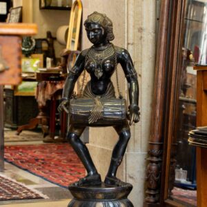 Bronze sculpture of a dancing woman playing the dholak drum